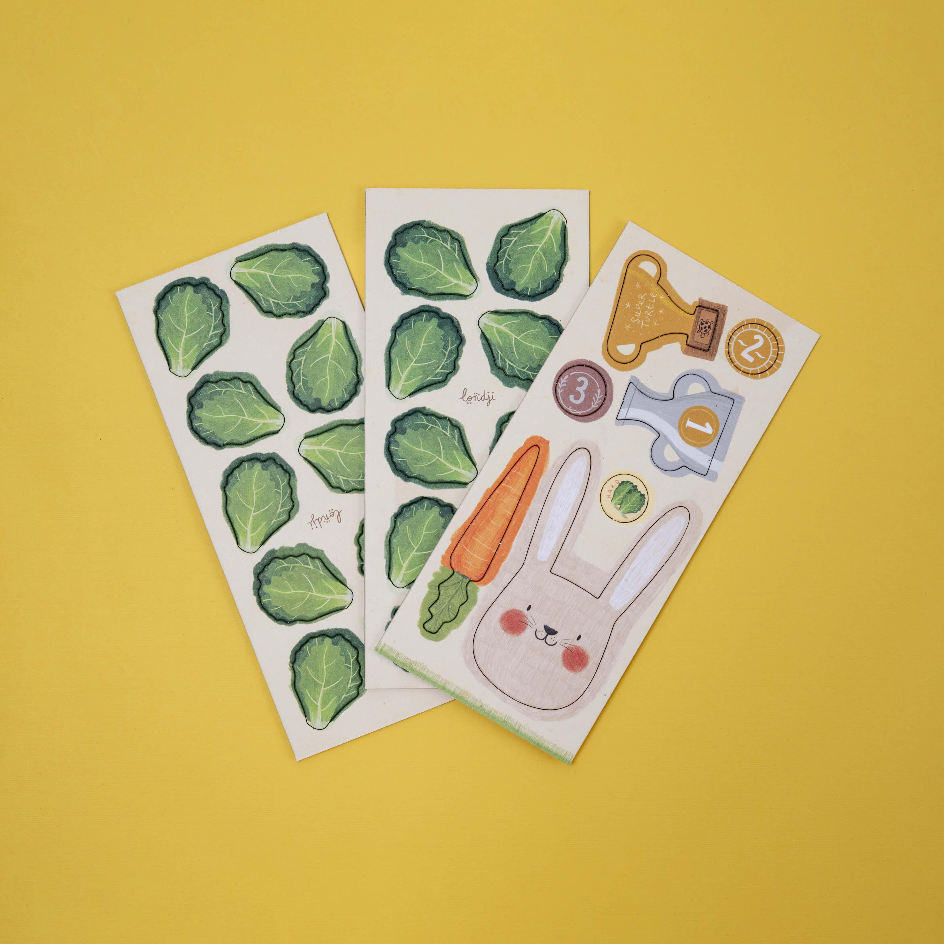 Londji three sheets of wooden cut out figures with green leaf patterns and a cartoon rabbit design on a yellow background.