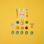 Londji set of wooden toys including a rabbit, carrots, turtles, and leaves on a yellow background