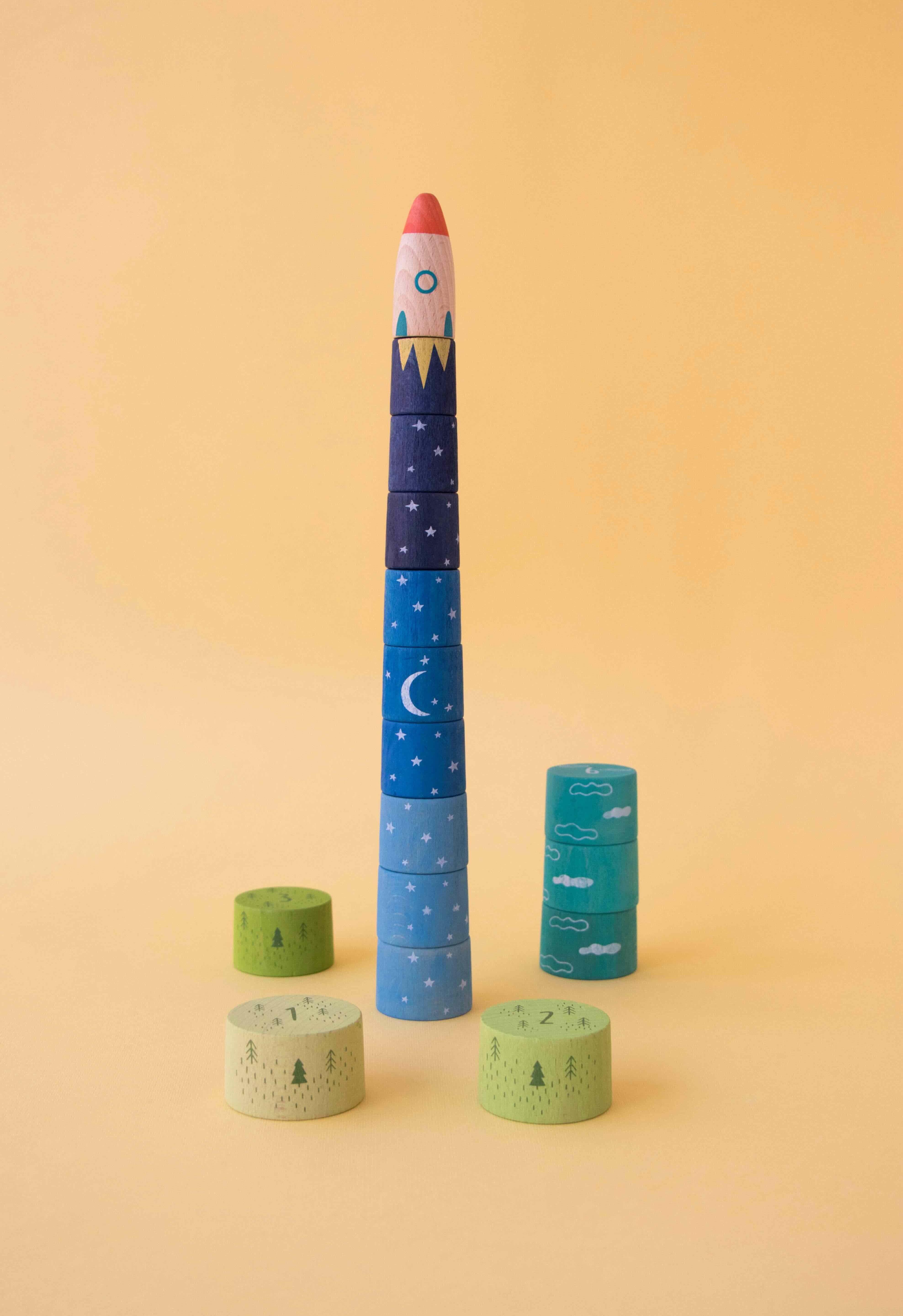 Londji stackable toy rocket with celestial design on a yellow background