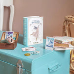 Book titled 'De Danse' on a teal surface with decorative items
