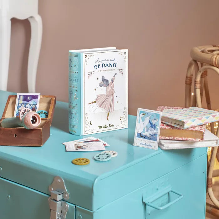 Book titled 'De Danse' on a teal surface with decorative items