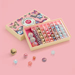 Billes & Co set with colourful marbles in a decorative box on a pink background