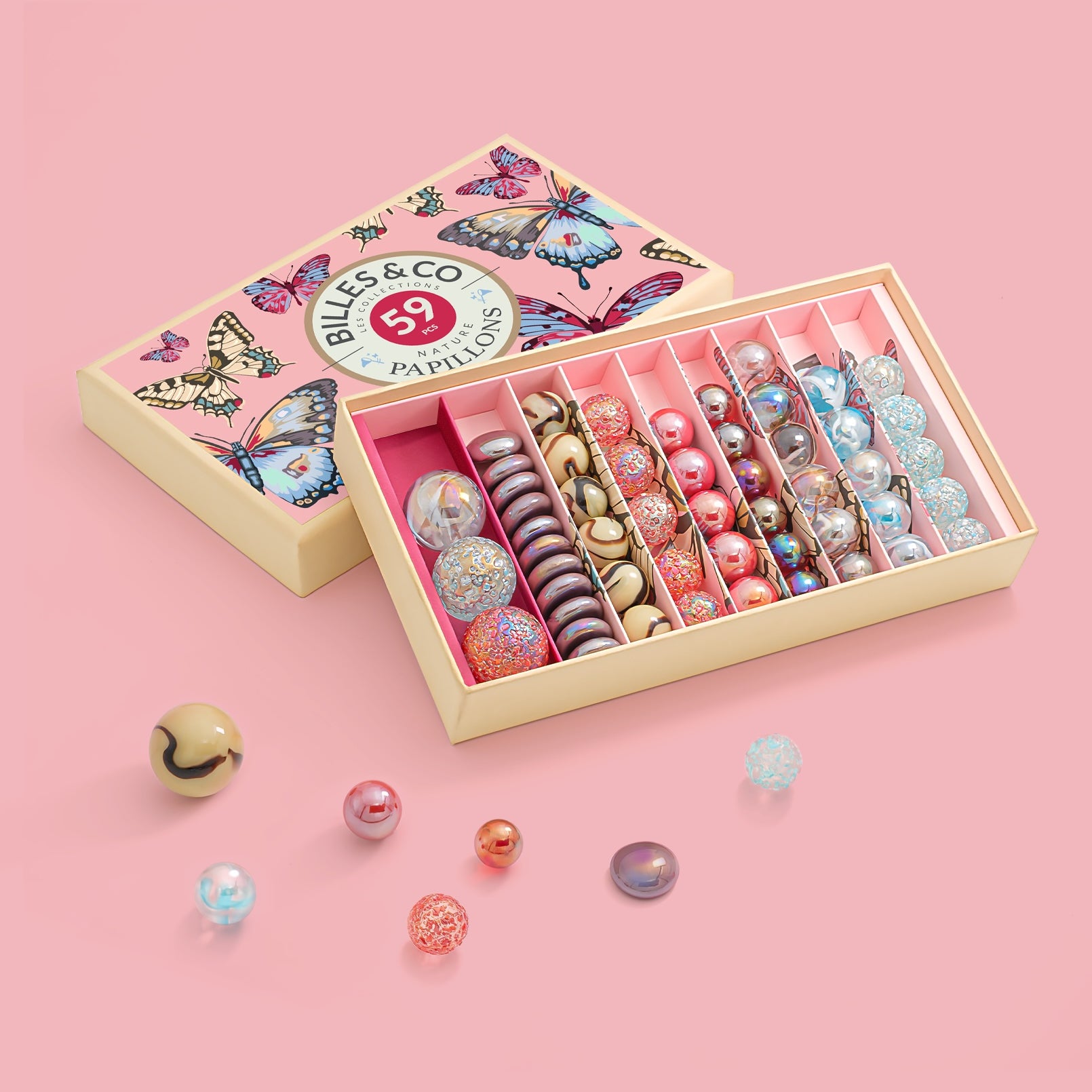 Billes & Co set with colourful marbles in a decorative box on a pink background