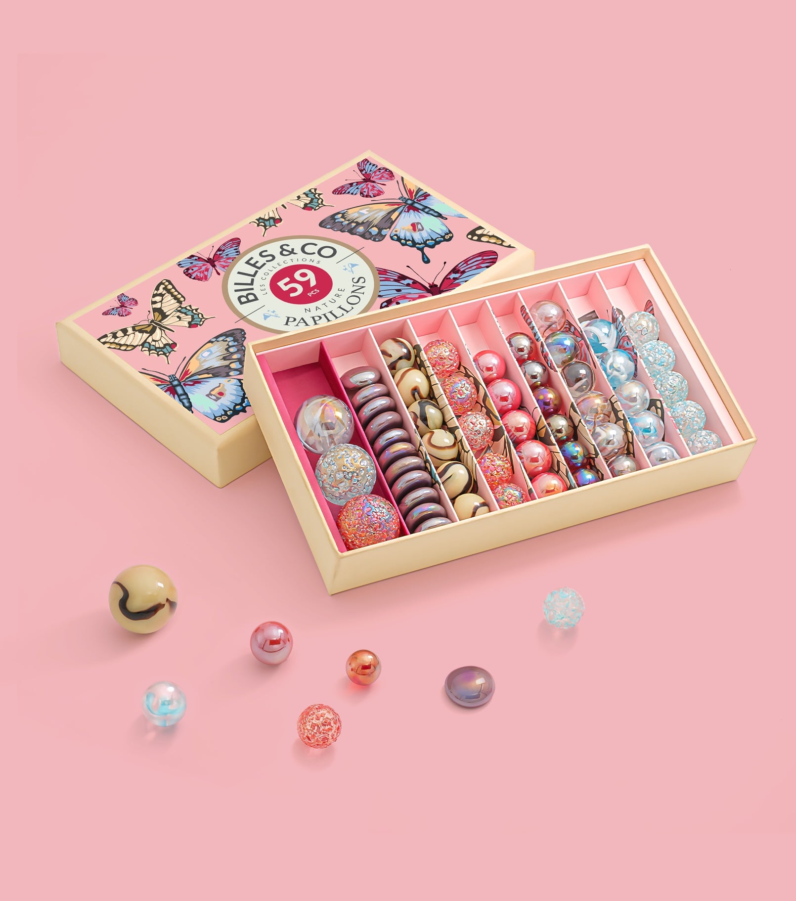 Billes & Co set with colourful marbles in a decorative box on a pink background