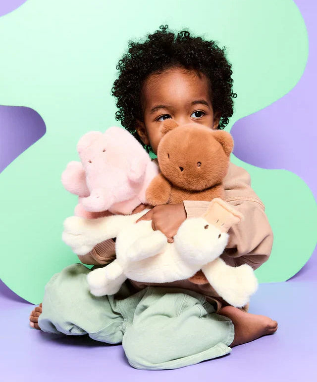 Child holding stuffed animals against a colorful background