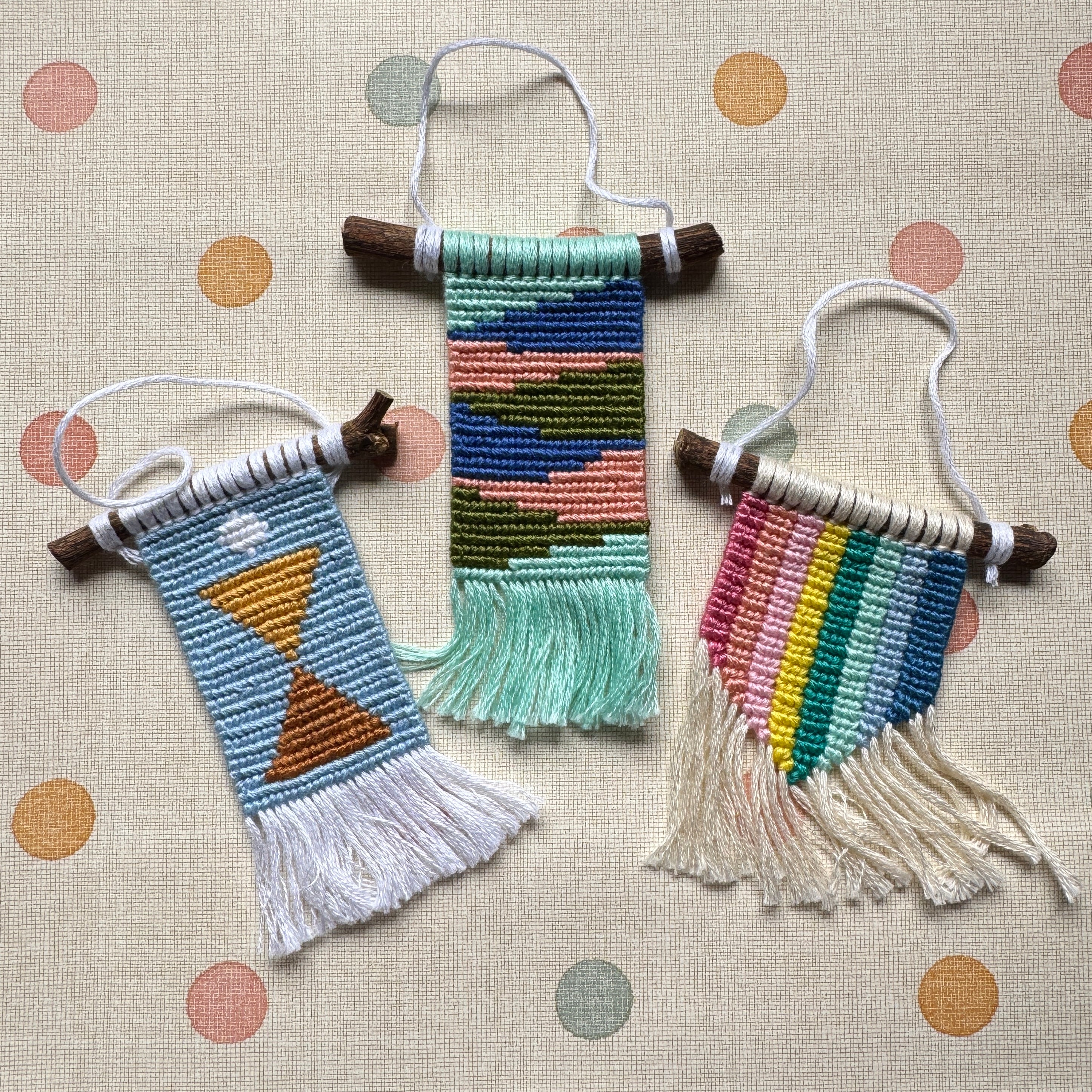 Three colorful woven wall hangings on a polka dot background