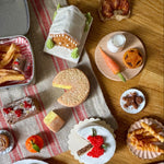 Assorted food items on a wooden table with a checkered cloth