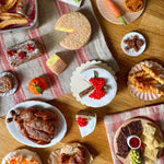 Assorted food items on a wooden table with a checkered cloth