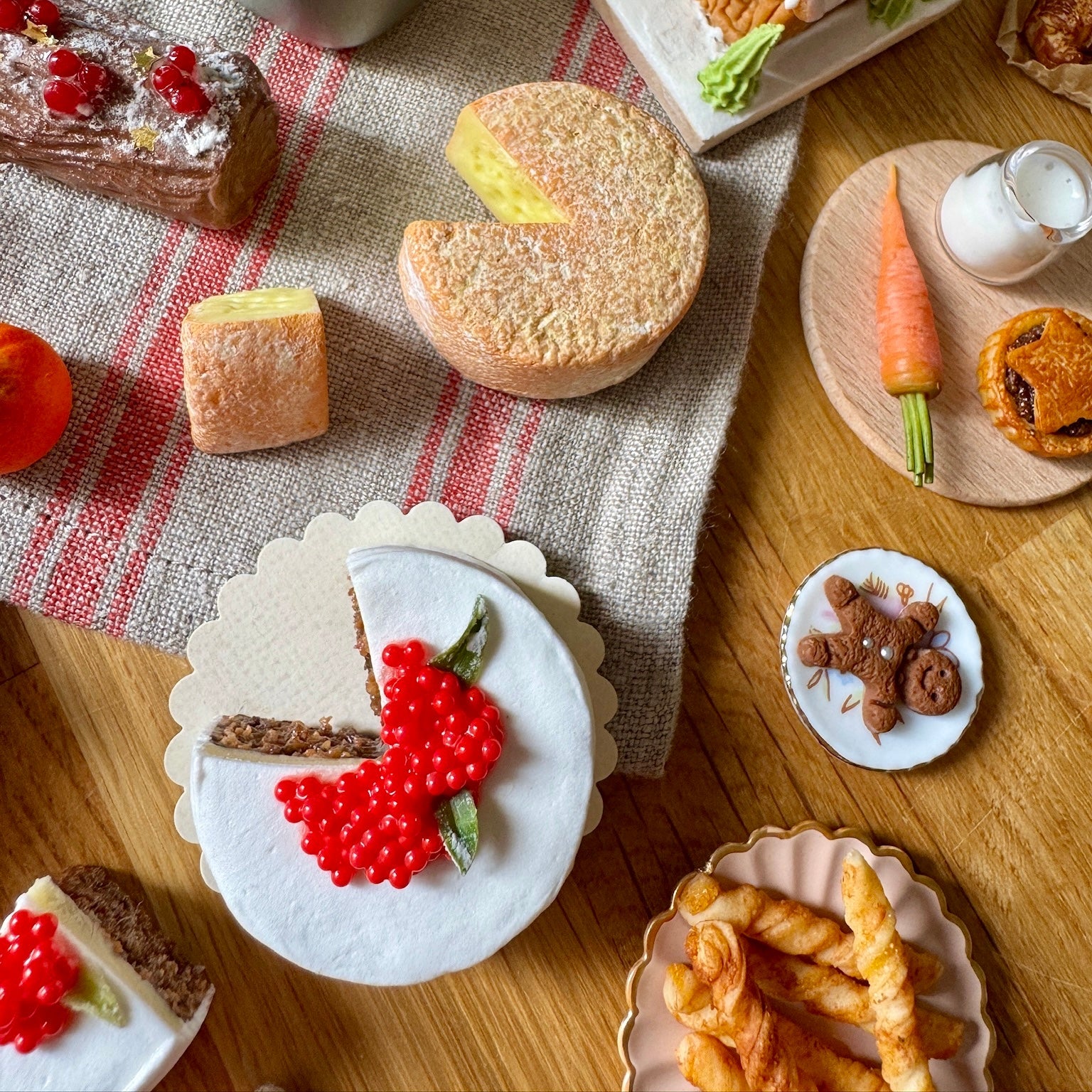 Various small food items and pastries on a wooden table with a checkered cloth.