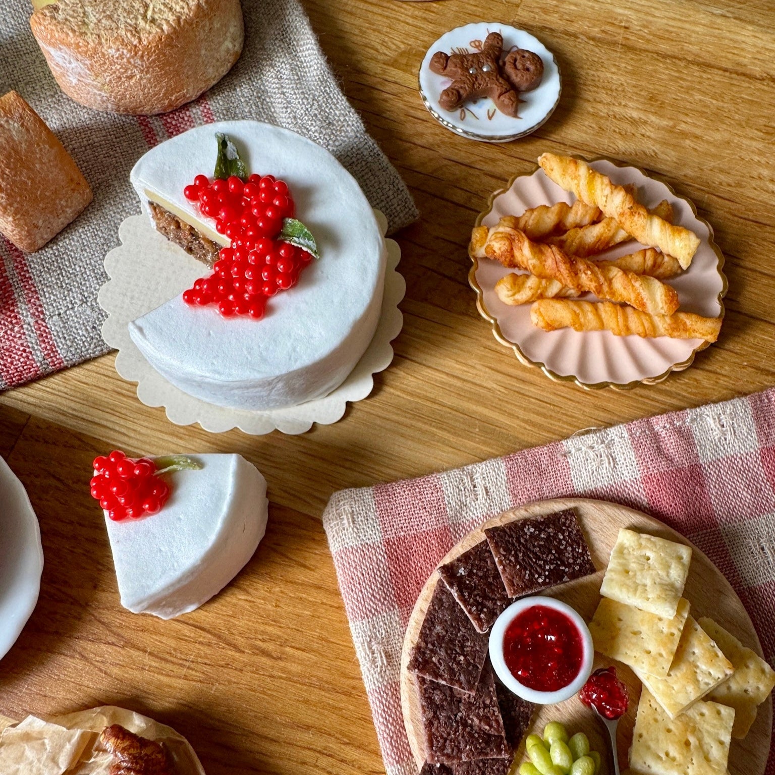 Assorted pastries and desserts on a wooden table with a checkered cloth.