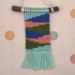 Handmade woven ornament with colorful pattern on a polka dot background