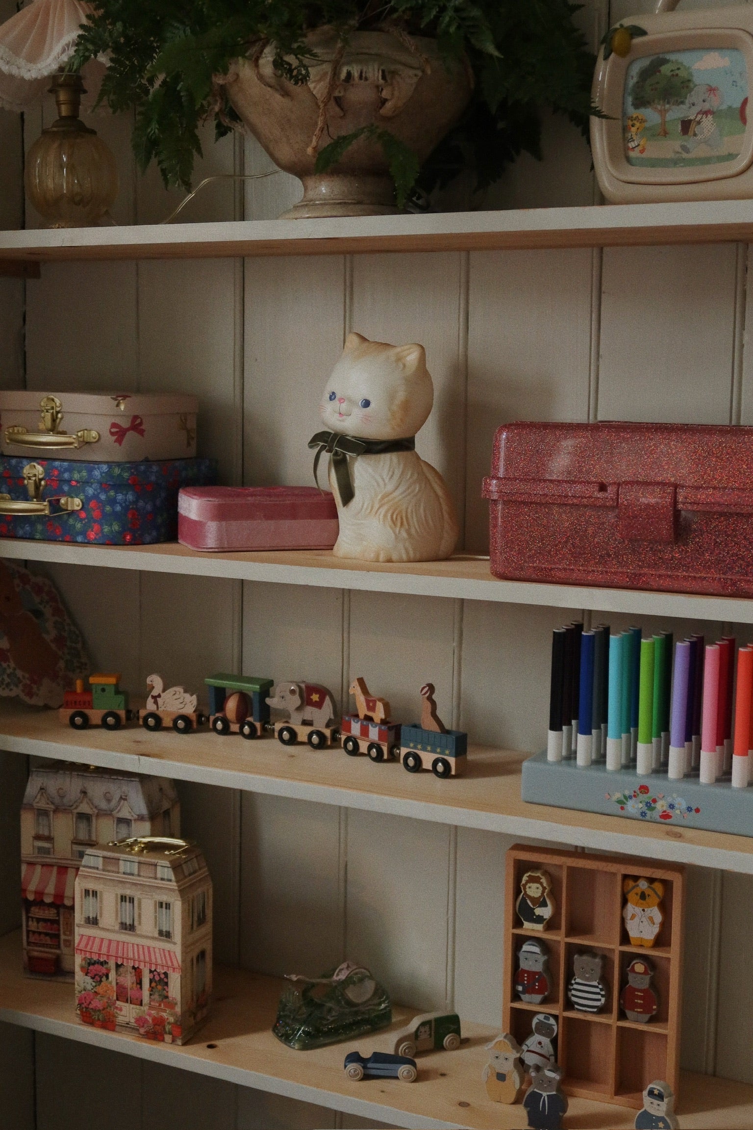 Shelf with various toys and decorative items against a neutral wall.