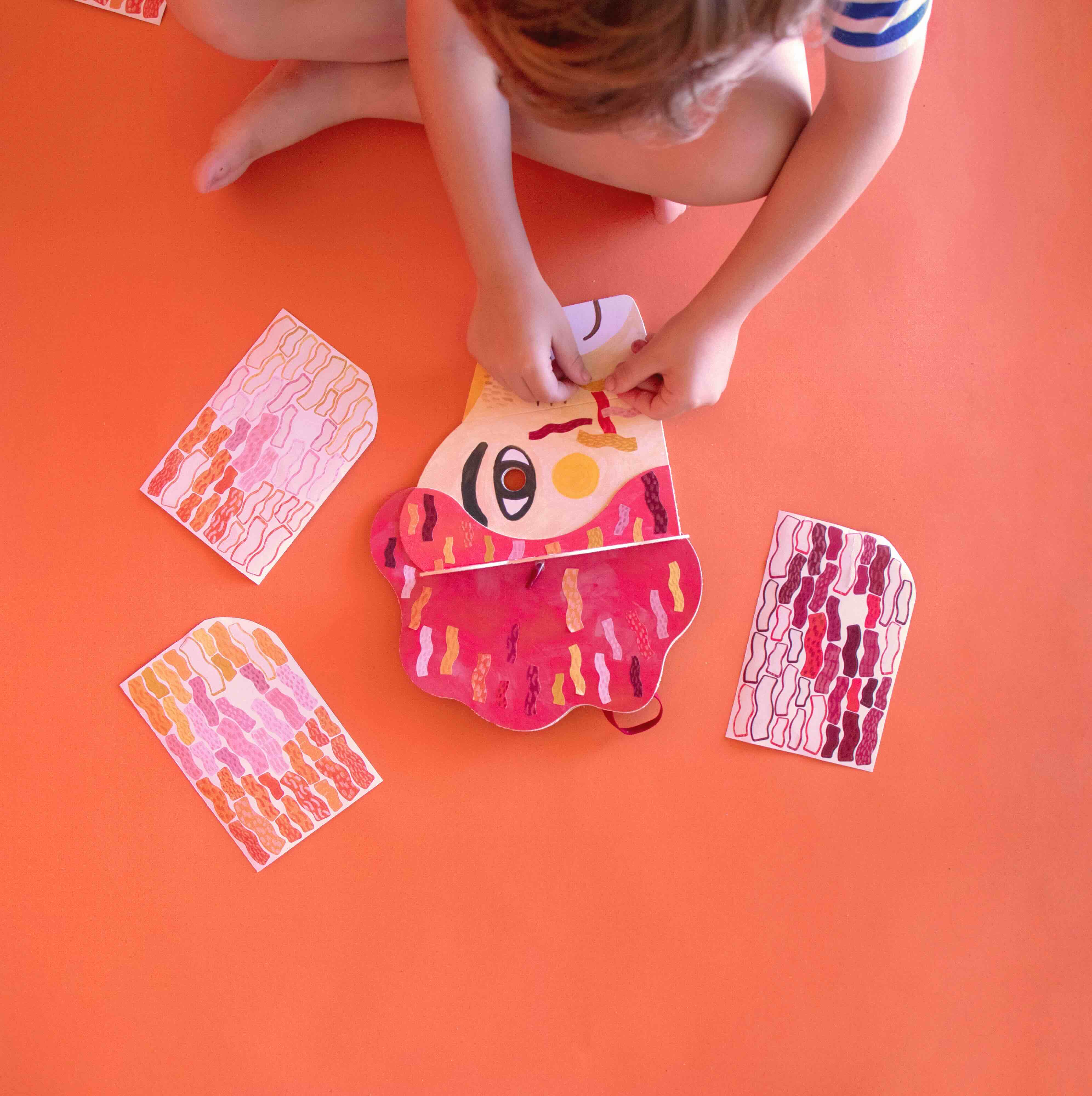 Child playing with colorful lion mask by Londji