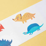 Londji colorful dinosaur tattoo illustrations on a white strip against a yellow background