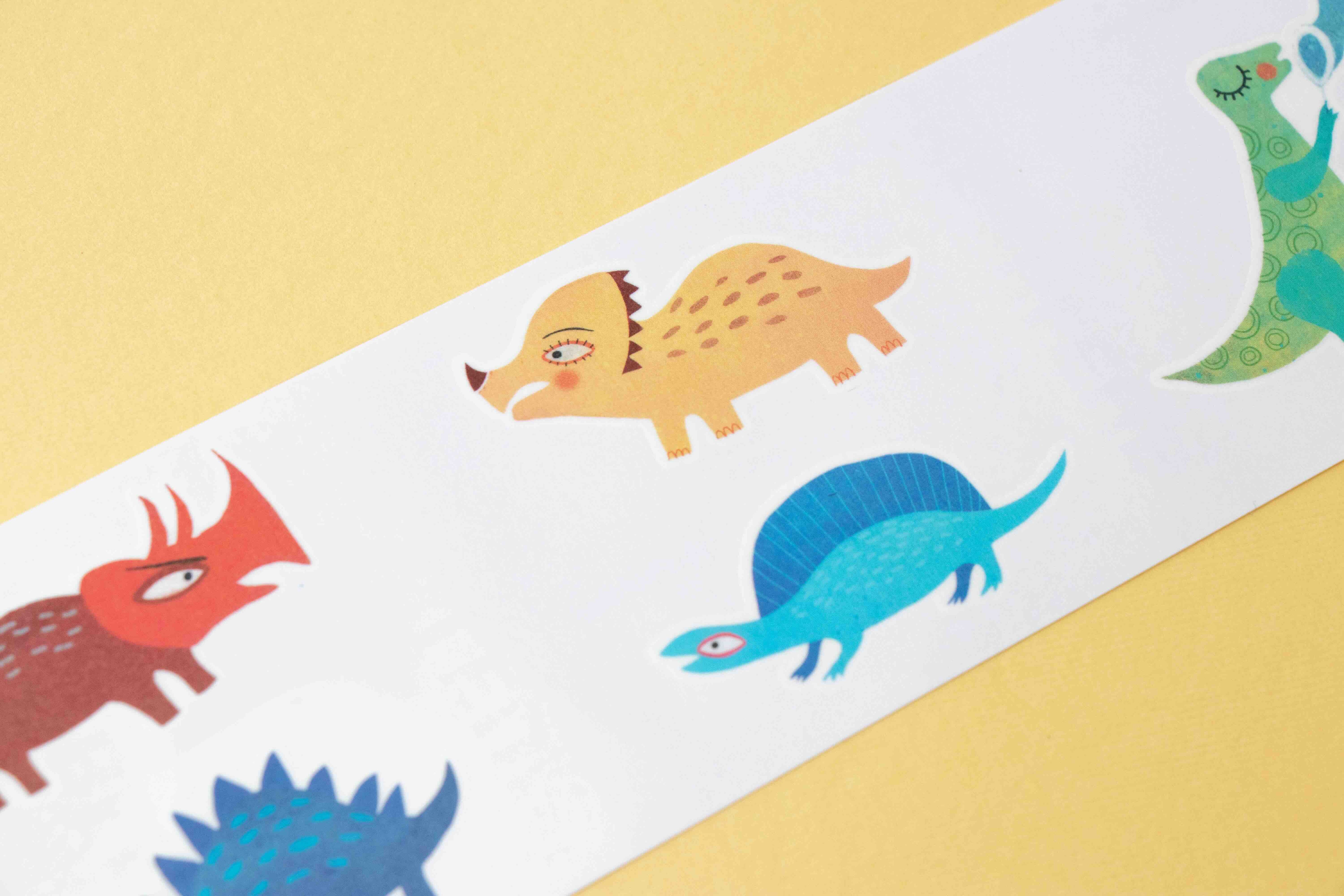 Londji colorful dinosaur tattoo illustrations on a white strip against a yellow background
