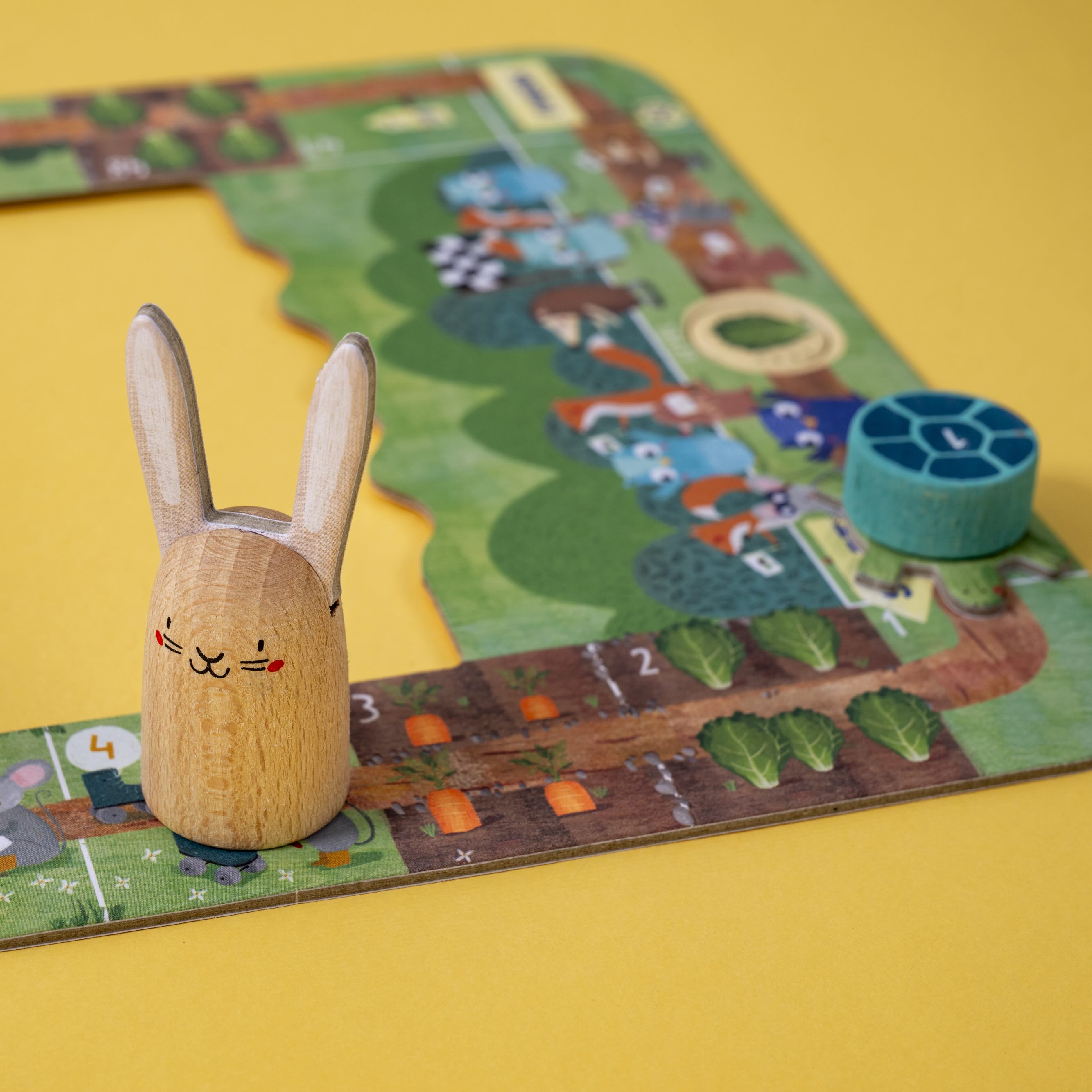 Londji wooden rabbit figure on a colorful board game with a yellow background