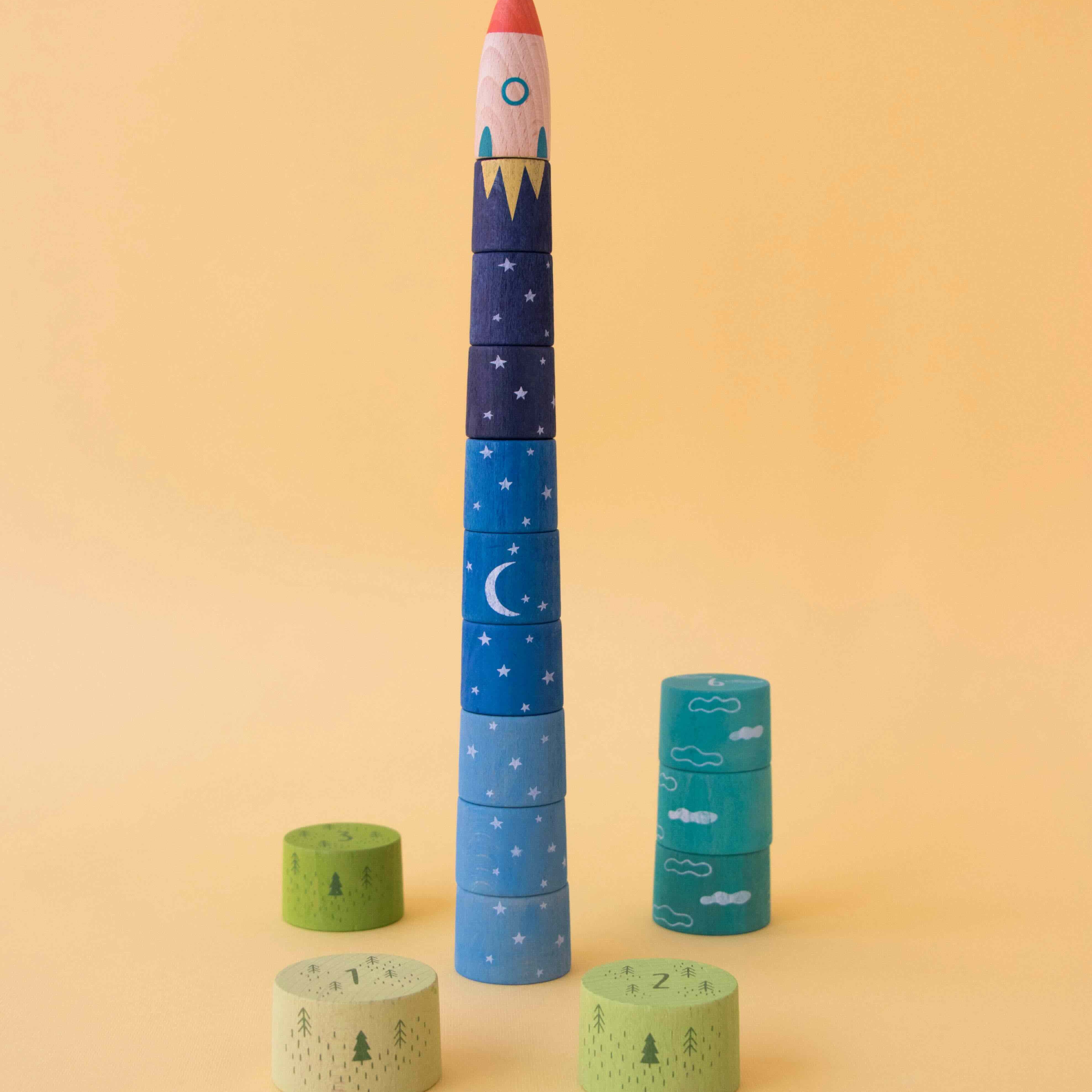 Londji stackable toy rocket with celestial design on a yellow background