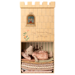 Maileg cardboard toy castle with stuffed animals and bedding inside on a white background