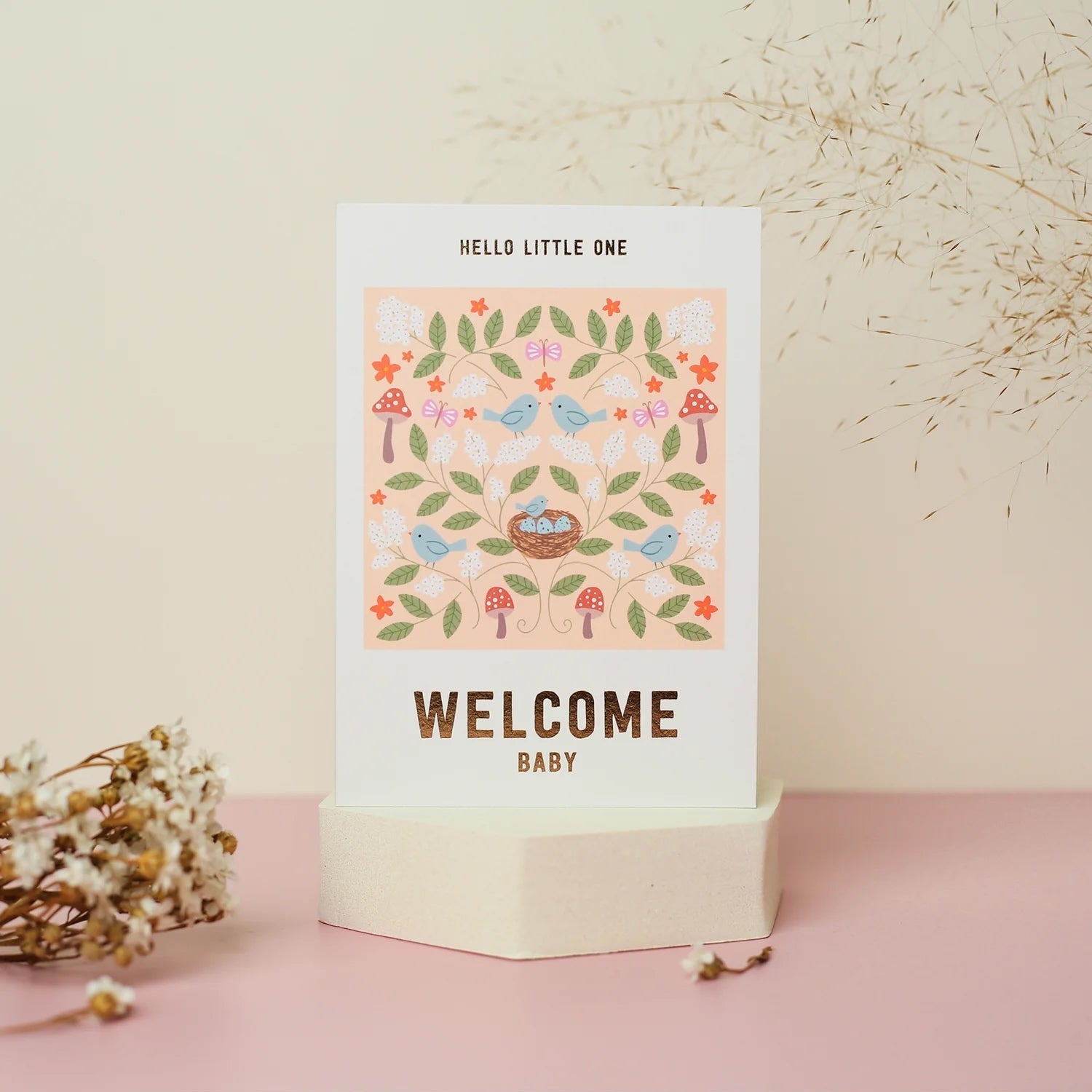 Mifkins baby shower card with birds, flowers, and 'Welcome Baby' text on a pink stand.
