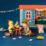 Moulin Roty toy set with plush animals and a small house on a blue background