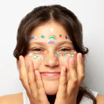 Girl with colorful OMY face stickers on a white background