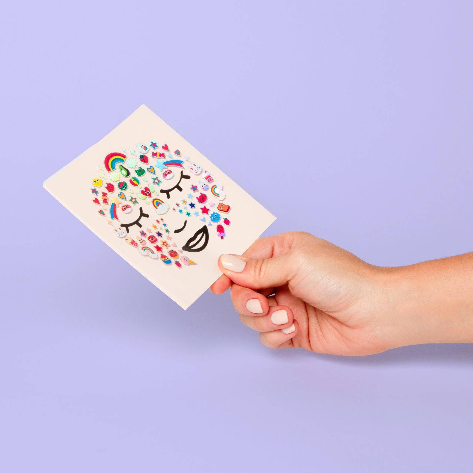 Hand holding a card with colourful OMY designs on a purple background