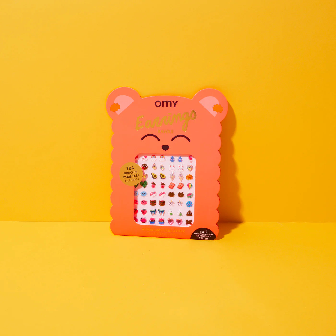 Packaged OMY earrings with bear designed packaging on a yellow background