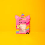 Pink packaging of OMY earrings on a yellow background