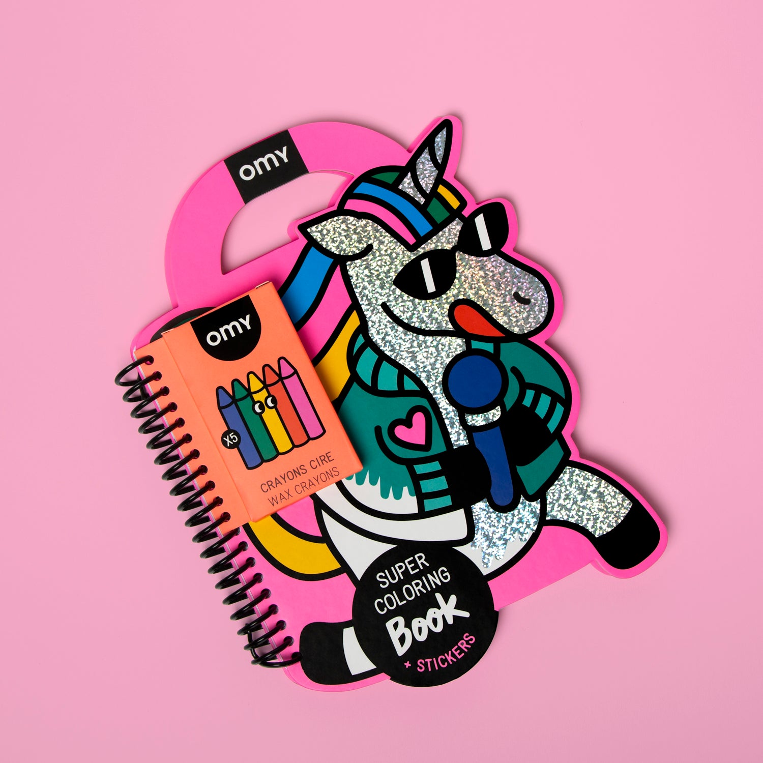 Colorful OMY unicorn-shaped coloring book and crayons on a pink background