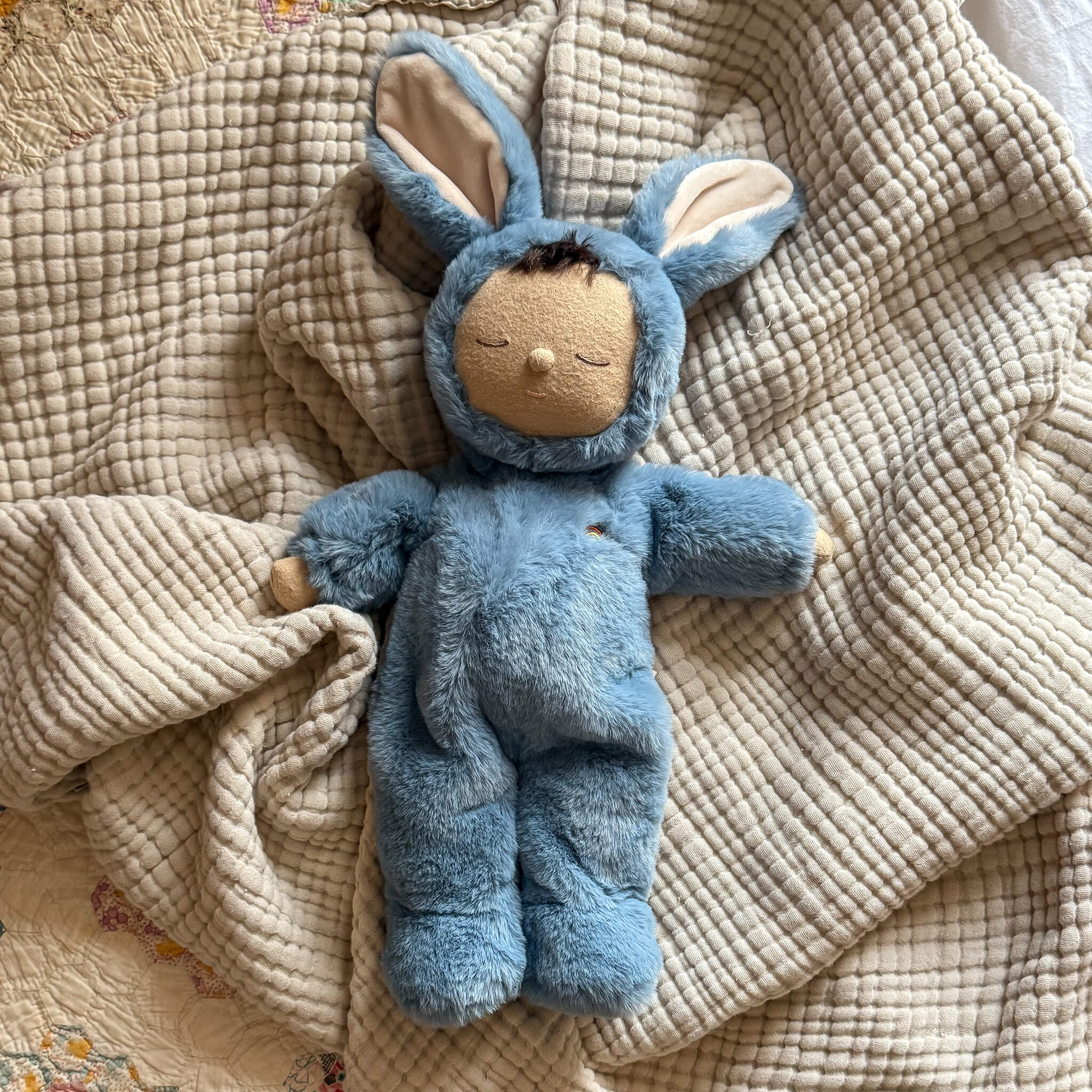 Olli Ella Cozy Dinkum Bunny Twiggy Blue on bedroom blanket